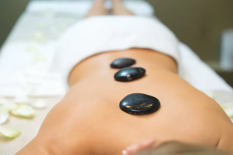 Woman with hot stone in therapy